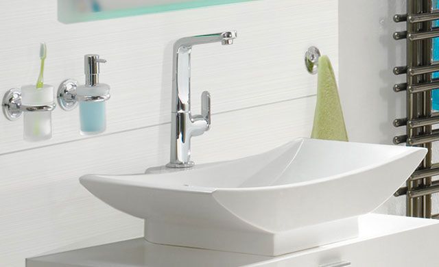 Fliesenserie KALMIT von Steuler Design | Foto: Panariagroup Deutschland GmbH Dunkle Strukturfliesen mit dreidimensionaler Oberfläche, daneben ein Waschtisch mit gelbem Handtuch und Waschbecken.